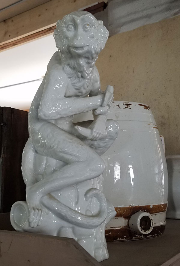 Vintage ceramic sculpture of monkey in showroom of Public Sale auction house in Hudson, NY.